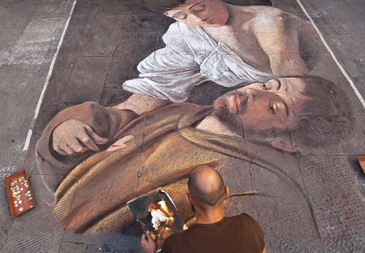 Artist creating a chalk painting on the street